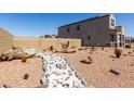 Backyard featuring desert landscaping, gravel groundcover, and a stone dry creek bed at 3932 N 306Th Ln, Buckeye, AZ 85396