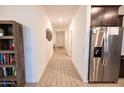 Extended hallway showcasing the home's layout and flow, with a view of the refrigerator and wooden shelving at 3982 E Sidesaddle Rd, San Tan Valley, AZ 85140