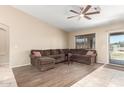 Spacious living room features tile flooring, a ceiling fan, and a sliding glass door at 6829 S 58Th Ave, Laveen, AZ 85339