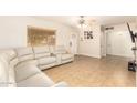 Bright living room with a sofa and tile flooring leading to the entry and other rooms at 6842 N 10Th Pl, Phoenix, AZ 85014