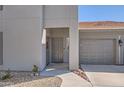 Exterior view of condo entrance and attached single car garage featuring landscaped yard at 7401 W Arrowhead Clubhouse Dr # 2045, Glendale, AZ 85308