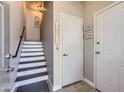 Entryway staircase has white risers and dark stained treads with decorative signs on wall at 7401 W Arrowhead Clubhouse Dr # 2045, Glendale, AZ 85308