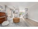 Bright living room featuring hardwood floors, piano, modern decor, and an open floor plan at 7567 W Andrea Dr, Peoria, AZ 85383