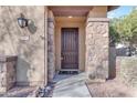 Close up of a beautiful solid wood door with stone columns on either side and a welcome mat at 857 S Osborn Ln, Gilbert, AZ 85296