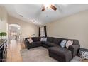 Inviting living room features a large sectional couch, neutral paint, tile flooring, and a ceiling fan at 1010 E Vernoa St, San Tan Valley, AZ 85140