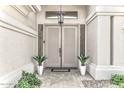 Elegant double doors are flanked by plants creating a grand entrance to this desert home at 14244 N 14Th Pl, Phoenix, AZ 85022