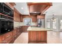 Traditional kitchen featuring custom wood cabinetry, stainless appliances, granite countertops, and a center island at 1614 W Beaubien Dr, Phoenix, AZ 85027