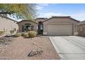 Charming front exterior of a single-story home with desert landscaping and a two-car garage at 21867 N Kirkland Dr, Maricopa, AZ 85138