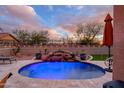 Tranquil pool featuring a rock waterfall and decorative lighting, creating a relaxing outdoor oasis at 23175 W Arrow Dr, Buckeye, AZ 85326