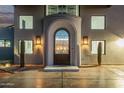 Close-up shot of the arched entryway with ornate iron door and desert landscaping at 29501 N 76Th St, Scottsdale, AZ 85266