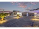 Exterior showcasing the driveway, desert landscaping, and three-car garage at 29501 N 76Th St, Scottsdale, AZ 85266