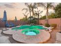 Beautiful pool area featuring a built-in spa, lush landscaping, and lounge chairs at 3482 E Cotton Ln, Gilbert, AZ 85234