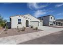 Picture of a single-story home with a three car garage and minimal landscaping at 35680 W Mallorca Ave, Maricopa, AZ 85138