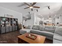 Spacious living room featuring a plush sectional, hardwood floors, and an open layout to the kitchen and dining area at 3797 E Taurus Pl, Chandler, AZ 85249