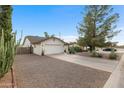 Charming single-story home with a two-car garage, gravel front yard, and mature desert landscaping at 449 E Fred Ave, Apache Junction, AZ 85119