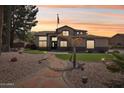 Charming two-story home with well manicured lawn and desert landscaping at dusk at 5613 W West Wind Dr, Glendale, AZ 85310