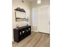 Stylish entryway with a decorative shelving unit, modern decor, and a brightly lit white front door at 6904 W Josac St, Glendale, AZ 85308