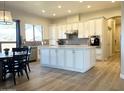 Bright kitchen features stainless steel appliances, a center island, and a separate dining area with hardwood flooring at 6904 W Josac St, Glendale, AZ 85308