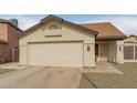 A single-story home featuring a two-car garage, low maintenance desert landscaping, and a security screen door at 7410 W Eva St, Peoria, AZ 85345