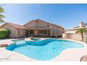 Inviting backyard featuring a sparkling pool, spa, and covered patio, perfect for relaxation and entertaining at 7910 W Adobe Dr, Glendale, AZ 85308