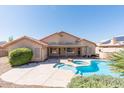 A serene backyard oasis offering a pool, spa, lush greenery, and a covered patio for outdoor enjoyment at 7910 W Adobe Dr, Glendale, AZ 85308