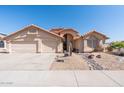 Charming single-story home with a well-maintained desert landscape and a spacious three-car garage at 7910 W Adobe Dr, Glendale, AZ 85308