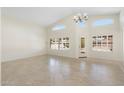 Spacious living room with tiled flooring, high ceilings, large windows, and modern lighting fixtures at 7910 W Adobe Dr, Glendale, AZ 85308