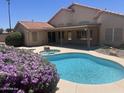 Gorgeous backyard pool and spa complemented by desert landscaping and covered patio at 7910 W Adobe Dr, Glendale, AZ 85308