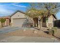 Single-story home with a two-car garage, stone accents, neutral stucco and low-maintenance desert landscaping at 8005 S 69Th Ln, Laveen, AZ 85339