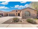 Lovely home featuring a three-car garage, an arched window, and landscaped desert foliage at 8432 S 21St Pl, Phoenix, AZ 85042