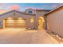 Charming home featuring a three-car garage, an arched entryway, and elegant stone accents at 8432 S 21St Pl, Phoenix, AZ 85042