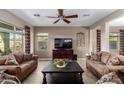 Cozy living room with neutral walls, tile floor, ceiling fan, and comfortable seating at 9286 W Buckhorn Trl, Peoria, AZ 85383