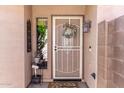 Inviting front entry with a decorative screen door, wreath, and outdoor lantern creates a welcoming atmosphere at 9857 E Fairview Ave, Mesa, AZ 85208