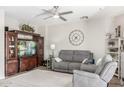 Comfortable living room features a cozy gray sofa, recliner, and large entertainment center with a TV at 9857 E Fairview Ave, Mesa, AZ 85208