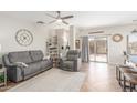 Bright living room features a gray sofa and recliner, and a sliding glass door with access to the backyard at 9857 E Fairview Ave, Mesa, AZ 85208