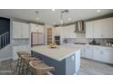 Bright, modern kitchen with white cabinets, an island, stainless steel appliances at 10013 E Trent Ave, Mesa, AZ 85212