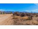 Scenic view of a desert property with mountain views in the background and a dirt driveway at 15519 E Windstone Trl, Rio Verde, AZ 85263