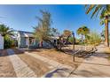 Inviting home featuring a driveway, mature trees and white picket fence at 1822 N Laurel Ave, Phoenix, AZ 85007