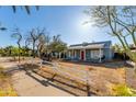 Charming home showcasing its light blue facade, red door, and white picket fence at 1822 N Laurel Ave, Phoenix, AZ 85007