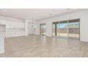 Open-concept living room with tile floors and sliding glass doors to the backyard at 20261 W Monterey Way, Buckeye, AZ 85396