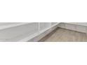 Spacious walk-in pantry with custom shelving and neutral tile flooring at 20261 W Monterey Way, Buckeye, AZ 85396