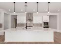 Bright kitchen featuring a large quartz island, stainless steel appliances, and modern pendant lighting at 20273 W Monterey Way, Buckeye, AZ 85396