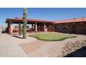 Putting green, covered patio area with tan building, cactus, rocks, and grass at 2263 N Trekell Rd # 81, Casa Grande, AZ 85122