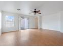 Bright living room with sliding glass doors, neutral paint, wood-look floors, and a ceiling fan at 2323 W Carson Rd, Phoenix, AZ 85041