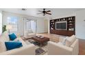 Bright living room with wood floors, white sofas, a ceiling fan, and built-in shelving at 2323 W Carson Rd, Phoenix, AZ 85041