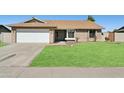 Inviting single-story home with a lush green lawn and convenient two-car garage at 4634 W Aire Libre Ave, Glendale, AZ 85306