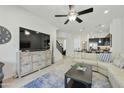 Open-concept living room with modern decor, ceiling fan, and adjacent staircase to the second floor at 4777 S Fulton Ranch Blvd # 1103, Chandler, AZ 85248