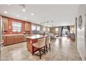 Open-concept kitchen featuring an island with barstool seating and modern appliances at 6523 S 34Th Dr, Phoenix, AZ 85041