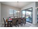 Dining room with modern table and chairs, contemporary lighting, and sliding glass doors to the backyard and outdoor space at 7250 N 80Th Ln, Glendale, AZ 85303