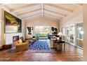 Bright and airy living room featuring terracotta floors, beamed ceilings, a fireplace, and access to the outdoor space at 84 Biltmore Est --, Phoenix, AZ 85016